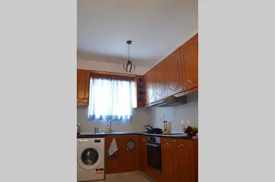 a kitchen with wooden cabinets and a washing machine at Vitro art House-in the heart of Chania in Chania Town