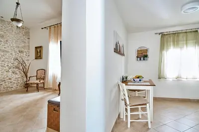 a living room with a table and a chair at Ekavi Apartment in Kissamos