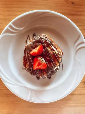 a chocolate cake with strawberries on a white plate at Elafonisi Rooms For Rent in Elafonisi
