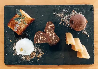 a black plate topped with different types of desserts at Elafonisi Rooms For Rent in Elafonisi