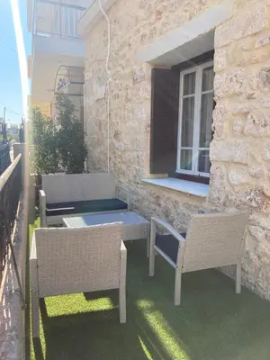 a patio with two chairs and a table and a window at Reina House in Chania Town