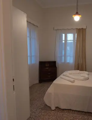a bedroom with a bed and a dresser and a window at Reina House in Chania Town