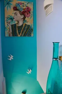 a painting of a woman next to a blue bottle at Casa Anthos free parking in Chania Town