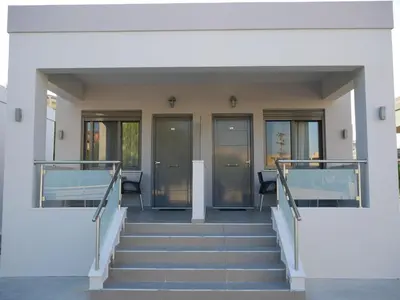 a staircase leading up to a building with glass doors at Erotokritos Studios near the beach in Agia Marina Nea Kydonias