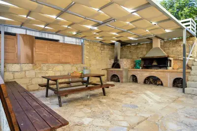 a patio with a picnic table and an outdoor oven at Villa Abelizia in Chania Town