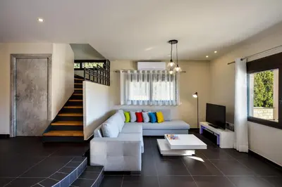 a living room with a couch and a staircase at Villa Abelizia in Chania Town
