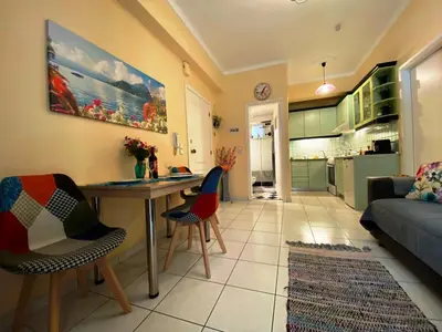 a kitchen and living room with a table and chairs at The Green Apartment, 1 min walk from Kalamaki beach in Kalamaki Chanion