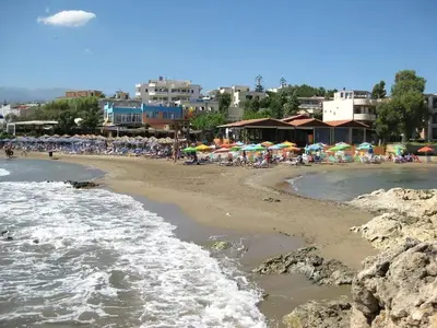 a beach with many chairs and umbrellas and people at The Green Apartment, 1 min walk from Kalamaki beach in Kalamaki Chanion