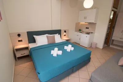 a bedroom with a blue bed with white pillows at Libyan Sunrise in Palaiochóra