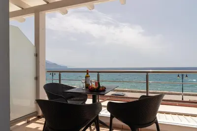 a balcony with a table and chairs and the ocean at Libyan Sunrise in Palaiochóra