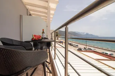 a balcony with a table and chairs and a view of the ocean at Libyan Sunrise in Palaiochóra