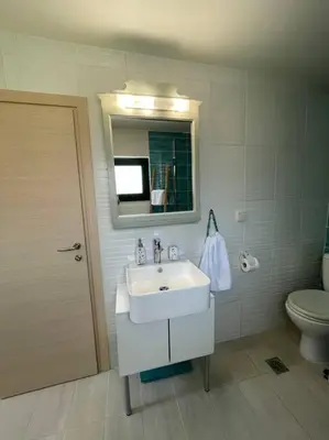 a bathroom with a sink and a toilet and a mirror at Maria`s Peaceful Nest in Chania Town