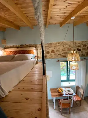 a bedroom with a large bed and a table at Maria`s Peaceful Nest in Chania Town