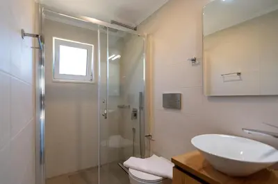 a bathroom with a sink and a glass shower at Bitsakis Family II - Paleochora Luxury House in Palaiochóra