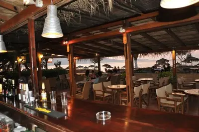 a bar in a restaurant with tables and chairs at Camping Mithimna in Kissamos