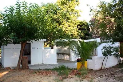 a white house with a tree in front of it at Camping Mithimna in Kissamos