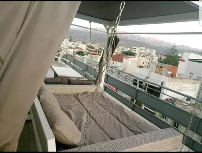 a bed on a balcony with a view of a city at Penthouse Apartment in Chania Heart in Chania Town