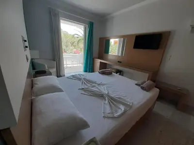 a bedroom with a large white bed with a window at Kyriaki Hotel in Kato Daratso