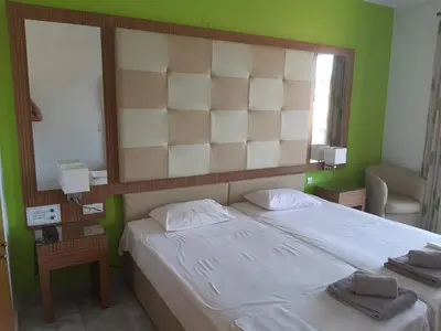 a bedroom with a large bed with a large headboard at Kyriaki Hotel in Kato Daratso