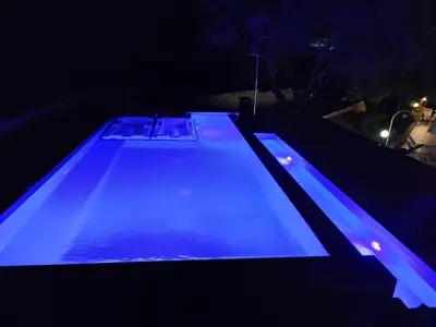 a swimming pool lit up in blue at night at Kyriaki Hotel in Kato Daratso