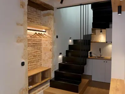 a black staircase in a room with a brick wall at Eva Plus in Chania Town