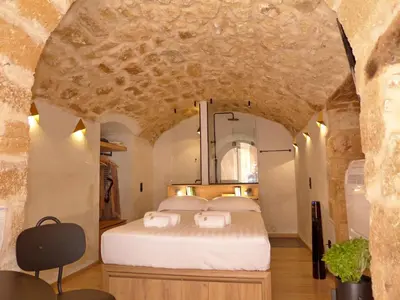 a bedroom with a large bed in a stone wall at Eva Plus in Chania Town