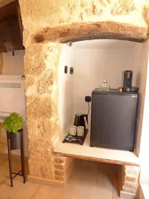 a tv sitting in a room with a stone wall at Eva Plus in Chania Town