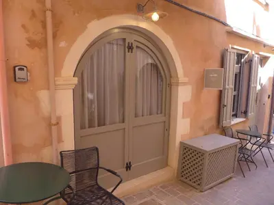a door with a table and chairs in front of a building at Eva Plus in Chania Town