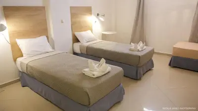 a hotel room with two beds with white shoes on them at Alexandra SeaSide Villas in Plataniás