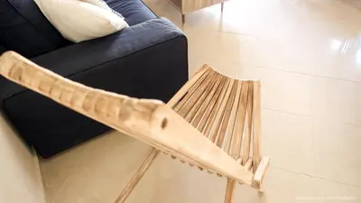 a wooden chair sitting next to a couch at Alexandra SeaSide Villas in Plataniás