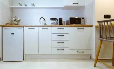 a kitchen with white cabinets and a sink at Iliovasilema Apartments in Elafonisi