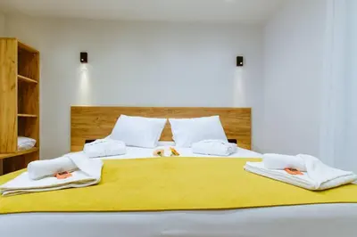 a large bed with white sheets and towels on it at Iliovasilema Apartments in Elafonisi