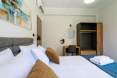 a bedroom with a white bed and a desk at Bitsakis Family - Paleochora Luxury Villa in Palaiochóra