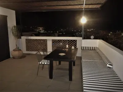 a table and chairs on a balcony at night at Cretan Loft in Plataniás