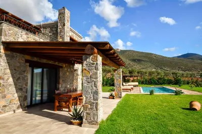 a stone house with a patio and a swimming pool at Villa Kore Elafonissi in Ãyios FÃ³tios