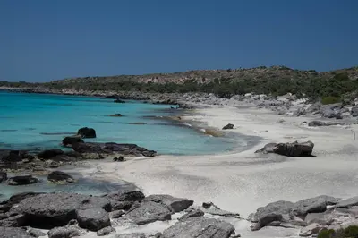 a beach with rocks and the blue water at Villa Kore Elafonissi in Ãyios FÃ³tios