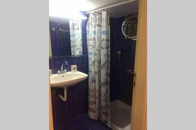 a bathroom with a sink and a shower curtain at Amelie Qute Apartment in Chania Town
