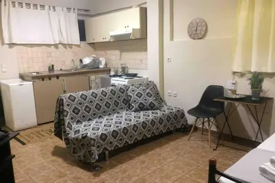 a living room with a couch and a kitchen at Amelie Qute Apartment in Chania Town