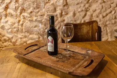a bottle of wine on a wooden tray with two wine glasses at History and Charm in Chania Town