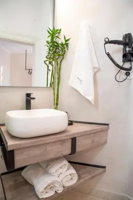 a bathroom with a white sink and a mirror at Horizon Villa Almyrida in Almirida