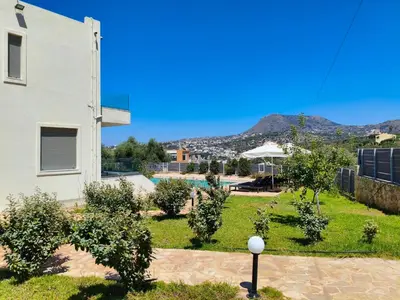 a view of the yard of a house with a pool at Horizon Villa Almyrida in Almirida