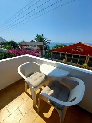 a white table and two chairs on a balcony at Agia Roumeli Hotel adults only in Agia Roumeli