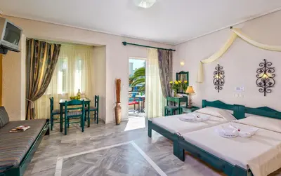 a hotel room with two beds and a living room at Castle Suites Hotel in Plataniás