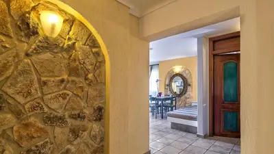 a stone wall in a hallway with a dining room at Castle Suites Hotel in Plataniás