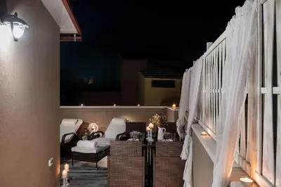 a balcony with chairs and a table with lights at Castello Luxury Residence with Private Jacuzzi in Chania Town
