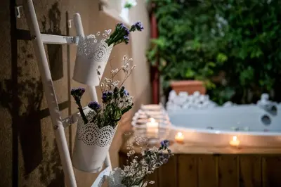 a couple of vases with flowers in them next to a bath tub at Castello Luxury Residence with Private Jacuzzi in Chania Town