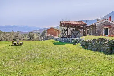 a house with a stone wall next to a field at Authentic Cottage in a heaven of natural Beauty in Chania Town