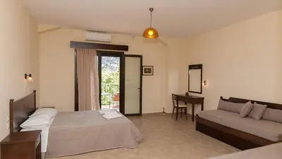 a bedroom with a bed and a couch and a table at Anopoli Rooms in Anopoli Sfakion