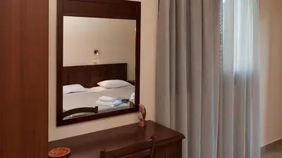 a bedroom with a mirror and a bed at Anopoli Rooms in Anopoli Sfakion