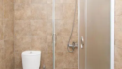 a shower stall with a toilet in a bathroom at Anopoli Rooms in Anopoli Sfakion